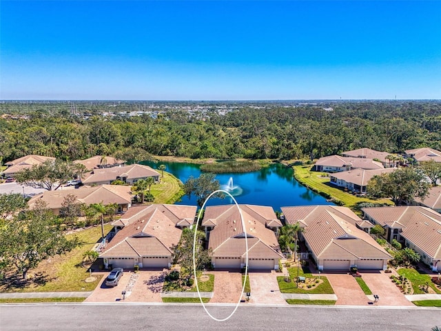 birds eye view of property featuring a view of trees and a water view