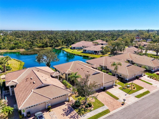 birds eye view of property featuring a residential view, a wooded view, and a water view