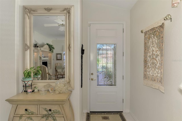 doorway with baseboards and ceiling fan