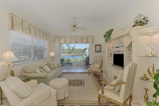 living area featuring ceiling fan and lofted ceiling