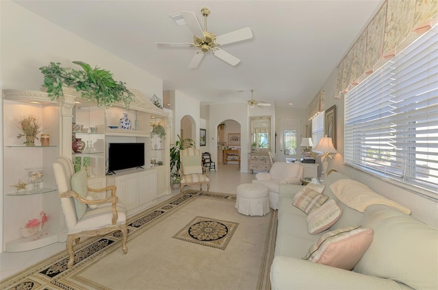 tiled living room featuring arched walkways and ceiling fan