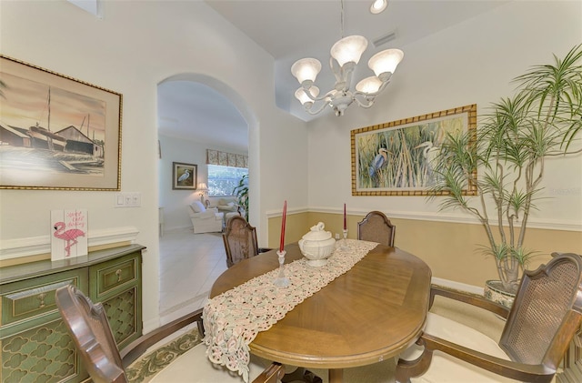 tiled dining area featuring a notable chandelier, visible vents, and arched walkways