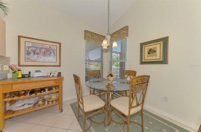 dining space featuring an inviting chandelier, light tile patterned floors, baseboards, and vaulted ceiling