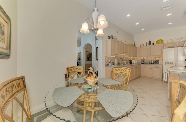 dining room with visible vents, a notable chandelier, arched walkways, light tile patterned floors, and lofted ceiling