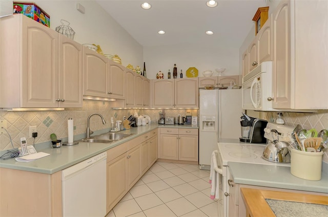 kitchen featuring white appliances, light countertops, and a sink