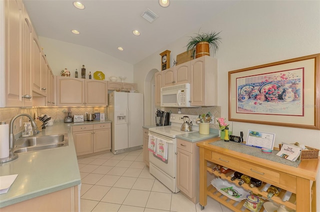 kitchen featuring visible vents, a sink, white appliances, light tile patterned floors, and lofted ceiling