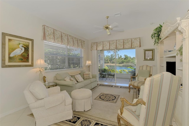 living area with visible vents, ceiling fan, vaulted ceiling, a water view, and tile patterned floors