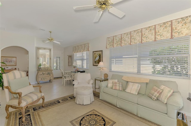 tiled living room with arched walkways and ceiling fan