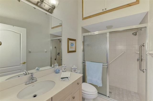 full bathroom featuring vanity, a shower stall, and toilet