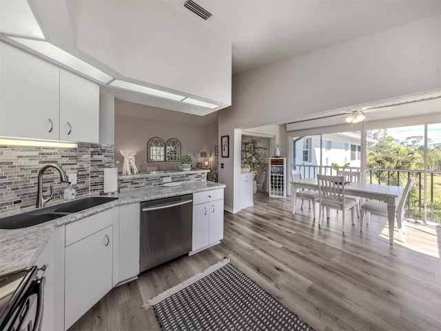 kitchen with white cabinets, dishwasher, backsplash, light wood-style floors, and a sink