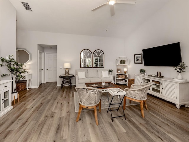 living room with light wood finished floors, ceiling fan, visible vents, and baseboards