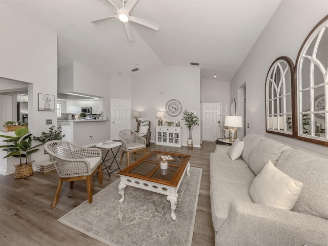 living area with ceiling fan, visible vents, high vaulted ceiling, and wood finished floors