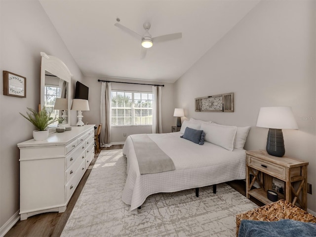 bedroom featuring lofted ceiling, ceiling fan, baseboards, and wood finished floors