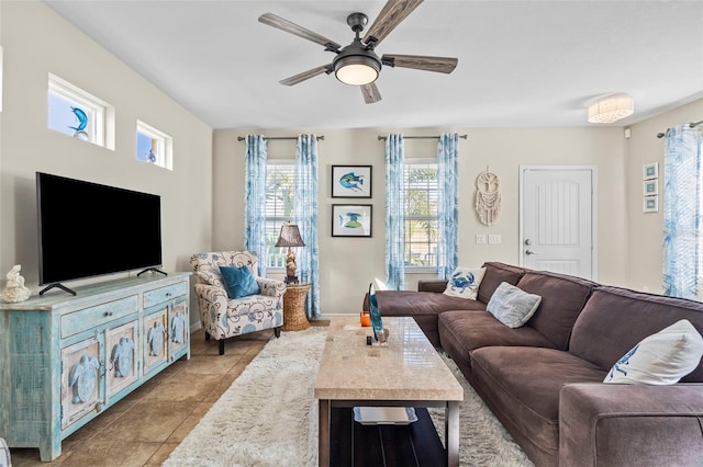 living area featuring ceiling fan, light tile patterned flooring, and baseboards