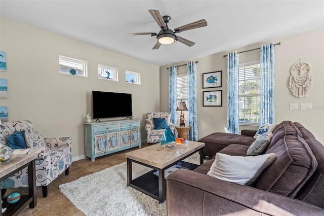 living room with a ceiling fan, baseboards, and light tile patterned floors