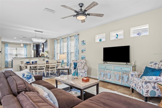 living room featuring ceiling fan, light tile patterned floors, visible vents, and a healthy amount of sunlight