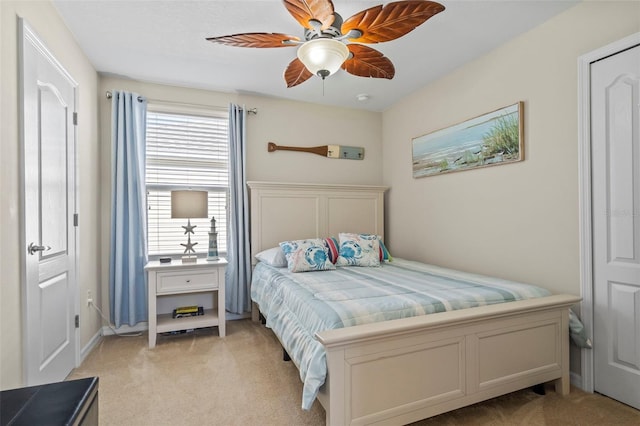 bedroom with light carpet, ceiling fan, and baseboards