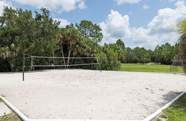 surrounding community with a lawn and volleyball court