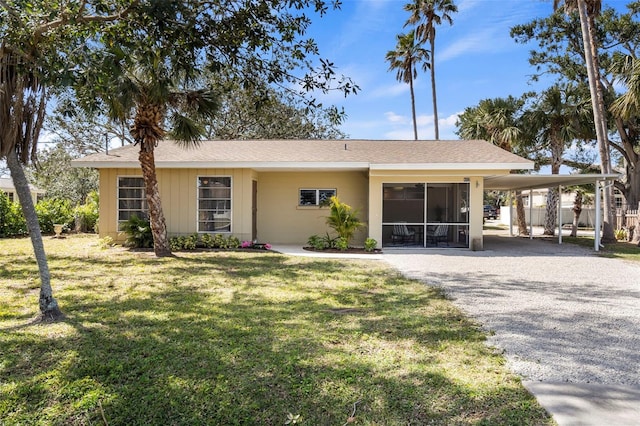 single story home featuring driveway, fence, a front lawn, and an attached carport