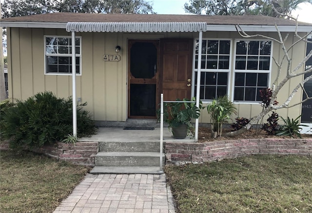 property entrance with a porch, board and batten siding, and roof with shingles