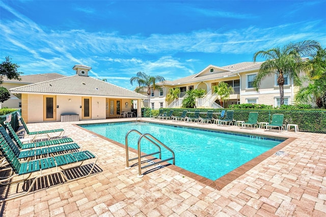 pool with a patio area and fence