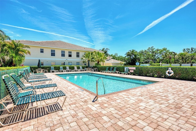 community pool with a patio and fence