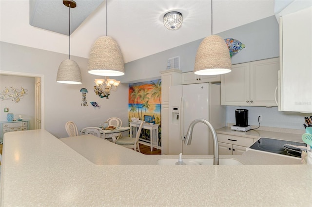 kitchen featuring light countertops, white refrigerator with ice dispenser, white cabinetry, and a notable chandelier