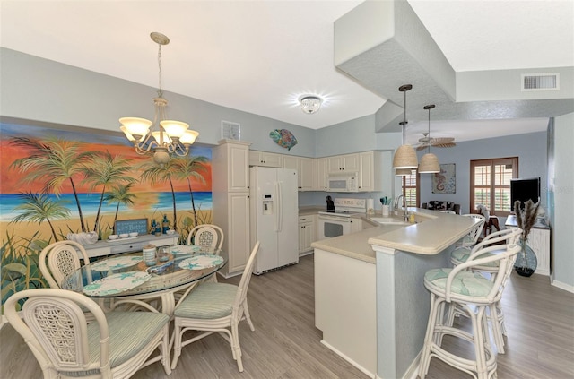 kitchen with white appliances, light wood-type flooring, visible vents, and a notable chandelier