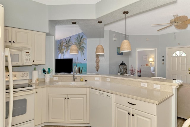 kitchen with decorative light fixtures, light countertops, a sink, white appliances, and a peninsula