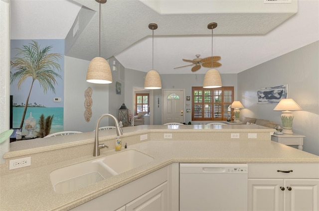 kitchen with open floor plan, decorative light fixtures, white dishwasher, light countertops, and a sink