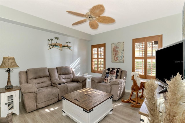 living area with light wood finished floors, plenty of natural light, and ceiling fan