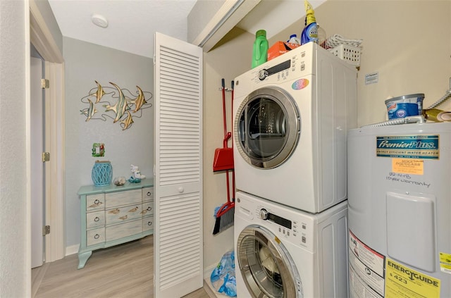 washroom with stacked washer and dryer, light wood-style flooring, laundry area, and electric water heater