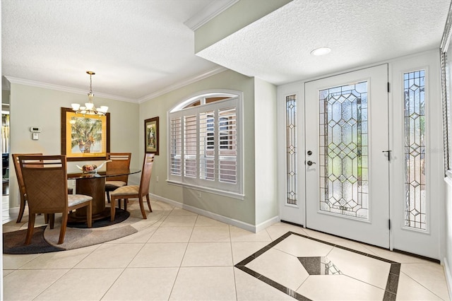 foyer with light tile patterned floors, baseboards, a textured ceiling, and ornamental molding