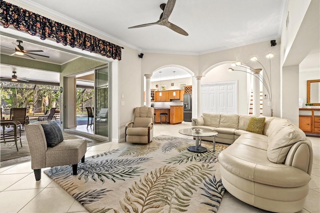 living room with ornamental molding, arched walkways, light tile patterned flooring, and decorative columns