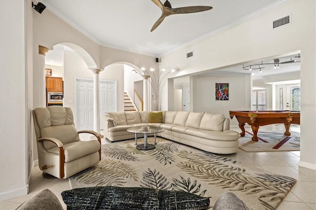 living area featuring light tile patterned floors, visible vents, and crown molding