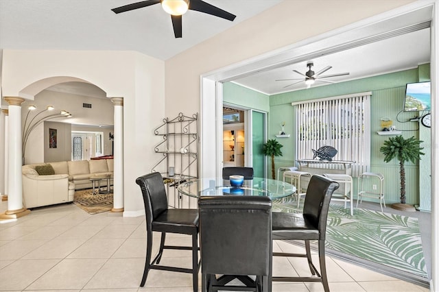 dining room with light tile patterned floors, plenty of natural light, arched walkways, ceiling fan, and ornate columns