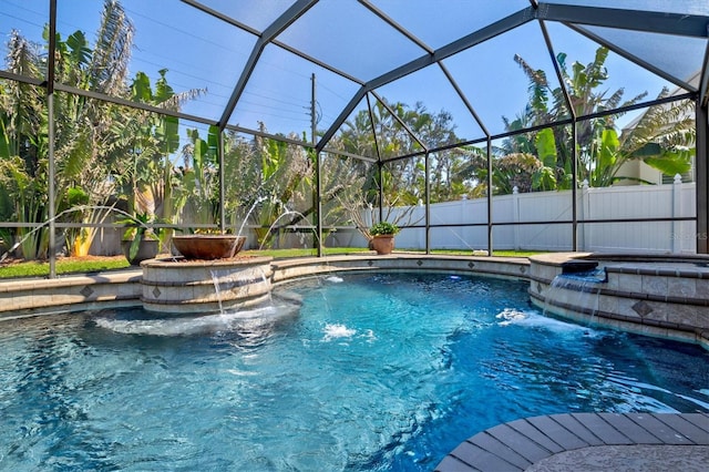 view of swimming pool with glass enclosure, fence, a fenced in pool, and a hot tub