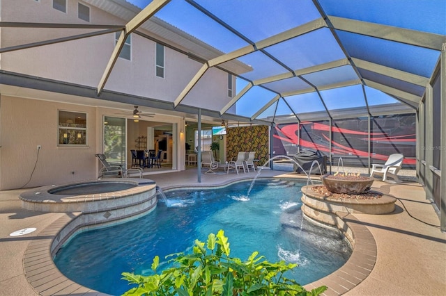 view of swimming pool with glass enclosure, ceiling fan, a fire pit, and a patio