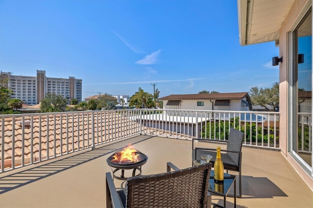 view of patio featuring a balcony and a fire pit