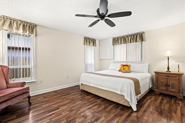 bedroom with a textured ceiling, ceiling fan, dark wood-type flooring, and baseboards