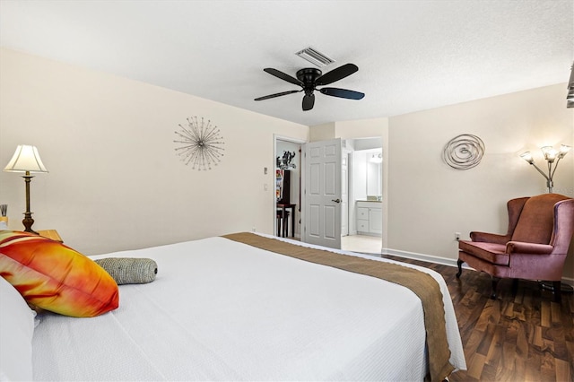 bedroom featuring wood finished floors, a ceiling fan, visible vents, baseboards, and ensuite bath