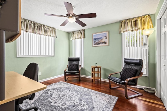 office space with ceiling fan, a textured ceiling, baseboards, and wood finished floors