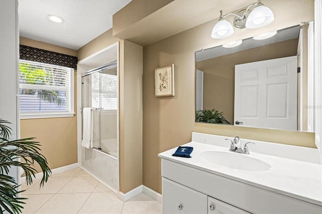 full bathroom featuring tile patterned flooring, combined bath / shower with glass door, vanity, and baseboards