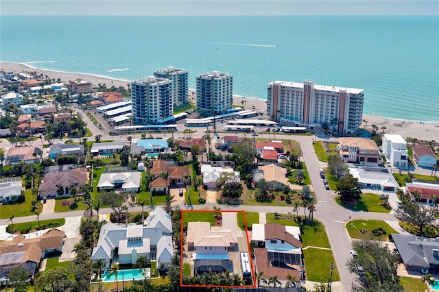 birds eye view of property with a water view, a view of city, and a beach view