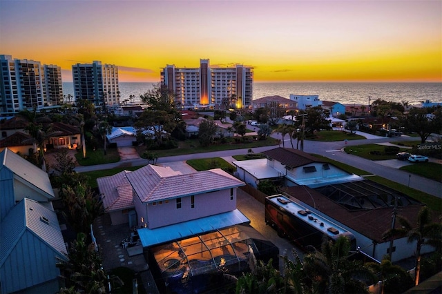 aerial view at dusk with a water view and a view of city