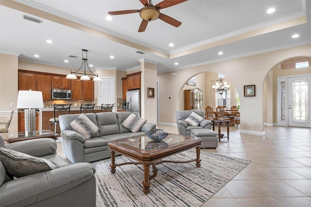 living area with arched walkways, a raised ceiling, light tile patterned flooring, and visible vents