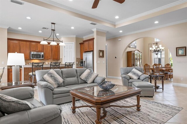 living area with light tile patterned floors, ornamental molding, arched walkways, and visible vents