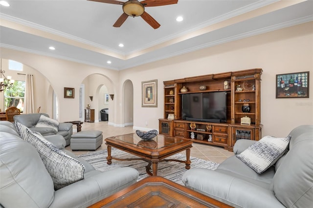 living area featuring arched walkways, a tray ceiling, light tile patterned flooring, and ornamental molding