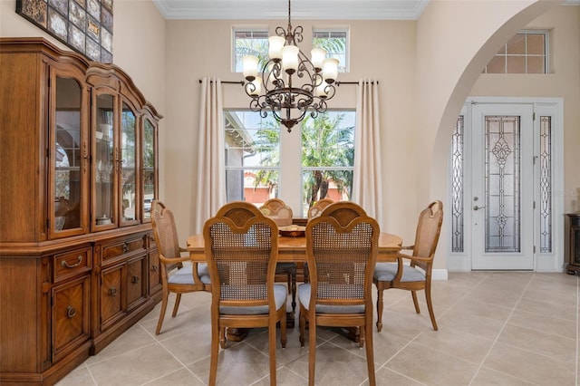 dining space with arched walkways, a healthy amount of sunlight, an inviting chandelier, and crown molding