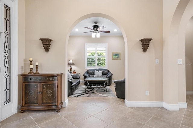 interior space with arched walkways, baseboards, and light tile patterned floors